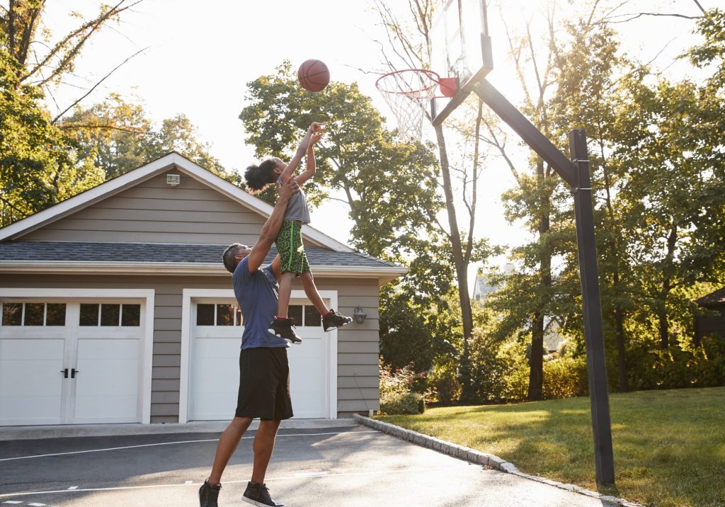 decorative photo - dad lifting child for basketball shot